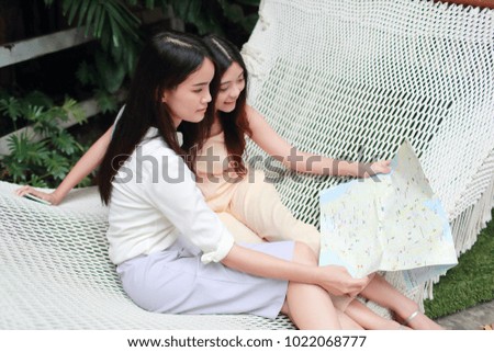 Young asian traveler searching direction on location map while traveling during holiday vacation
