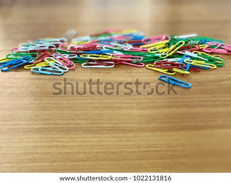 Colorful clip on brown wooden texture desk in teacher room school with blurred background