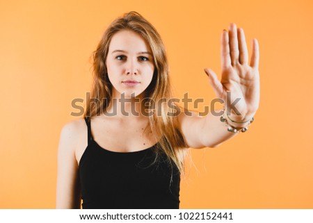 Attractive woman saying thanks but no. Beautiful girl denying proposal, making stop gesture with her hand