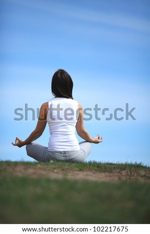 beautiful young girl training yoga on sunny meadow