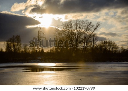 colorful winter sunset with trees and power lines in background and ice blocks