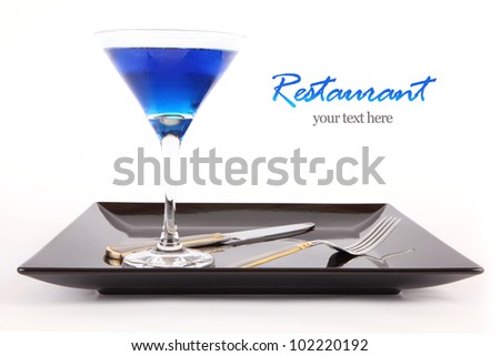 Restaurant Design Blue drink in a cocktail glass in black dish with fork and knife