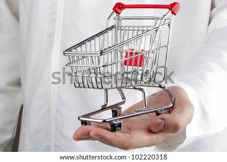 Close-up photograph of man's hand holding a shopping cart.