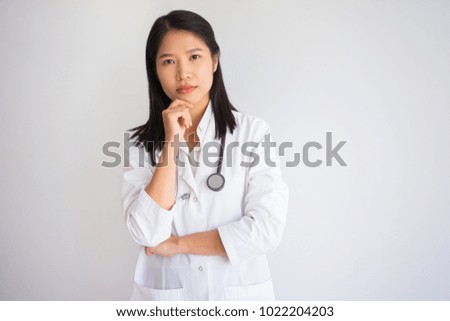 Pensive Young Female Doctor with Hand on Chin