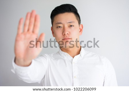Strict Asian Man Showing Stop Gesture