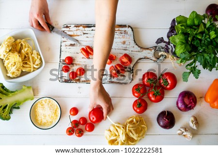 Top view womam hands. Food background. Food concept. Various fresh Ingredients for cooking. Picture of kitchen table with colorful vegetables . Sliced vegetables for making meal. Selective focus.