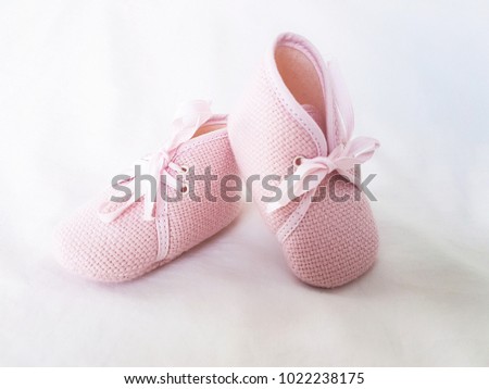 A little pink shoes on white background. It's a shoes that make by fabric that soft and good for a little baby or infant. Fashion and clothes for baby concept.