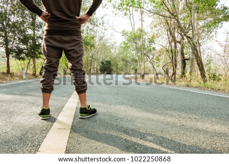 Runner athlete standing on road towards sun. Concept of new start, travel, freedom etc. Close up cropped low angle photo of shoe of athlete.
