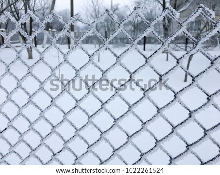Snow on iron fence and winter background. Snowflakes on metal fence. Snow covered metal fence close up