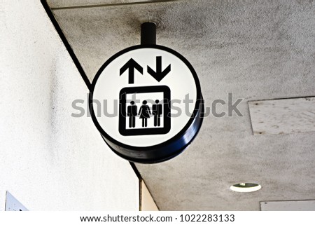 White lift or elevator symbol, sign on building wall background. Copy space