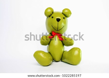Green leather bear with red bow in sitting post