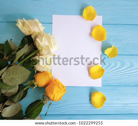 white and yellow roses on a blue wooden background place for text   blank white card
