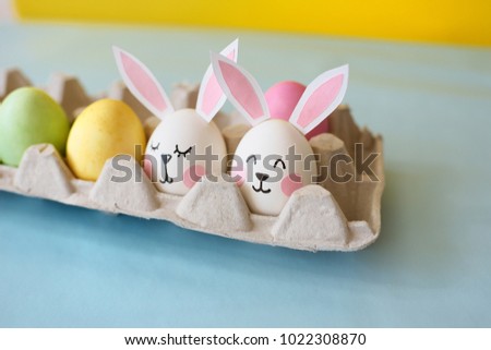 Happy Easter. Eggs with ears of rabbits, in an image of rabbits
