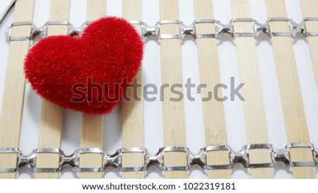 Red heart placed on  bamboo background.