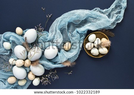 Easter composition with blue painted eggs and napkin on dark blue backround. Top view, flat lay, Holiday card.