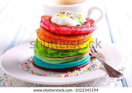Rainbow pancakes, served in pile on plate Royalty-Free Stock Photo #1022345194