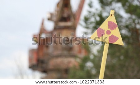 A sign of radiation hazard on the background of a construction crane. Chernobyl