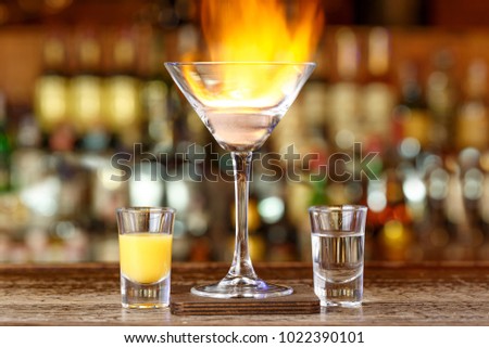 Cocktail on the basis of liquor Malibu and rum stand on a bar in a restaurant on a blurry background of bottles