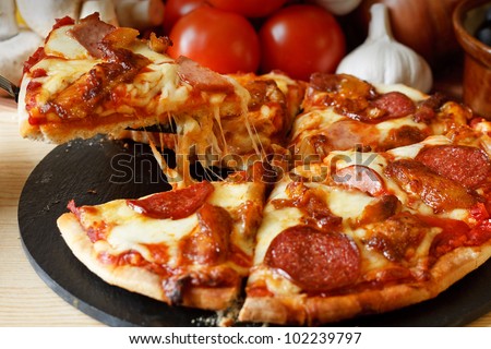 Meat feast Barbecue pizza with a topping of pepperoni, sausage, salami and chicken wings