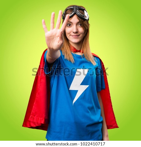 Pretty superhero girl counting four on colorful background