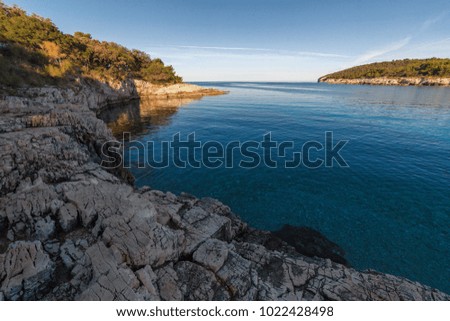 Stone coast of the Croatian Sea. Summer. Sunny weather. Sharp stones, clear blue sea.