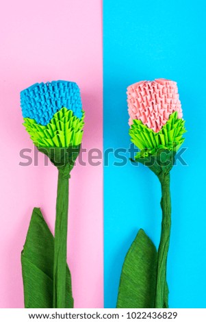 Multicolored paper origami flowers on pastel background. Studio Photo
