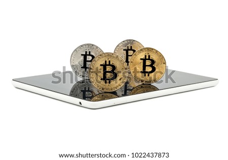 Gold and silver bitcoin coin on tablet close up