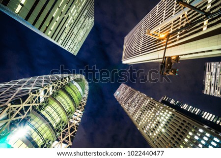Asia Business concept for real estate and corporate construction - looking up night view in shinjuku, the silhouettes of skyscrapers reflect twilight sky in Tokyo, Japan