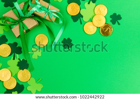 Saint Patrick's Day. Green three petal clovers and gold leprechaun  coins on green background