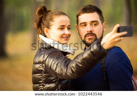 couple in love in autumn makes selfie