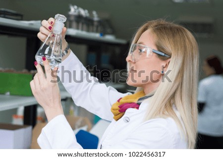 Portrait of a chemist holding a tube with liquid