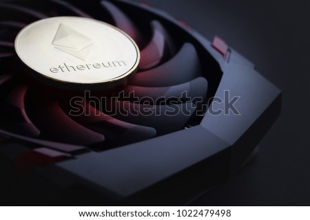 cryptocurrency mining concept with one golden Ethereum coin on top of a computer performant video card black fan Royalty-Free Stock Photo #1022479498