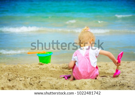 Baby girl playing in the sand on the beach