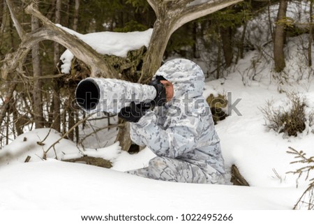 Wildlife photographer outdoor in winter. Photographer in winter camouflage