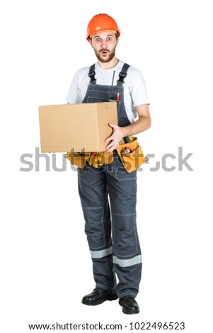 A man is a builder with a cardboard box in his hands. Isolated over white background