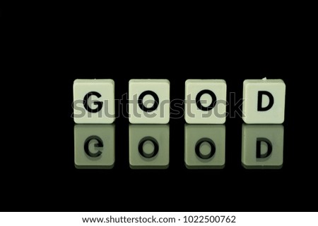 blocks with letters set on a glass table. Words arranged from letters on a glass substrate. The words good black background
