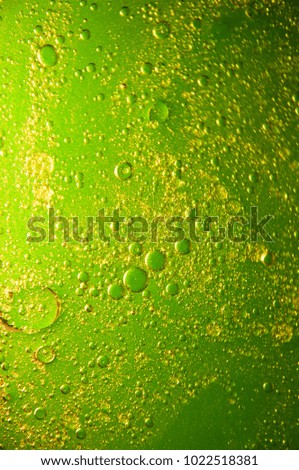 Oil and water are two liquids that will not mix together. green background