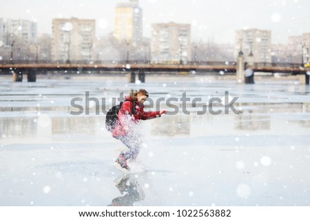 a young guy skating on a city ice rink on a frozen pond or river. Winter, winter entertainment, active lifestyle, figure skating.