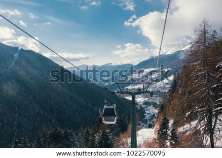 Beautiful winter day in the Alps with cable car going up the mountains.