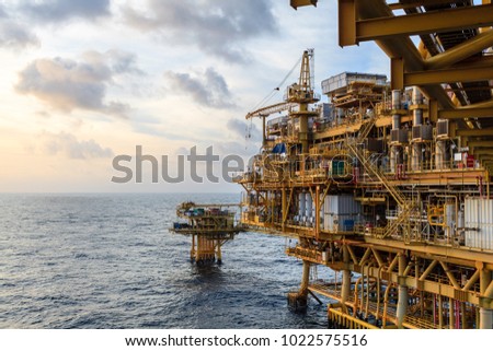 Offshore oil and Gas central processing platform and remote platform produced oil, natural gas and liquid condensate for set to onshore refinery from offshore in ocean sea background. Royalty-Free Stock Photo #1022575516