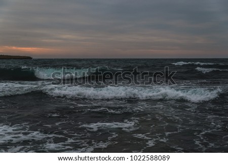 Storm at sea in cloudy weather at sunset, dramatic mood of nature