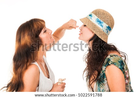 Two women. One another does the make-up. She paints her lips, and face. Smile, twisted. Isolated photo on the white background. You can use cosmetics advertising, lipsticks, makeup basics