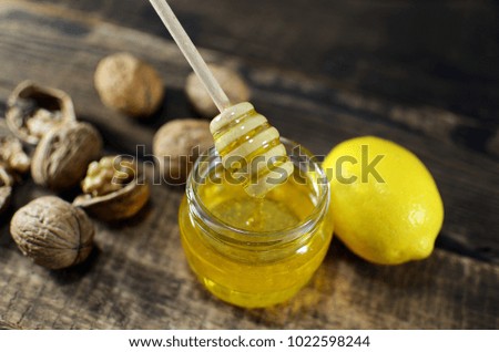 honey with walnuts and lemon on a wooden background