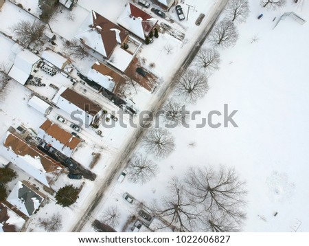 Aerial bird eye view skyline at Winter season in Canada. Hundreds of low rise houses from top view in the background covered in high level of snow. 