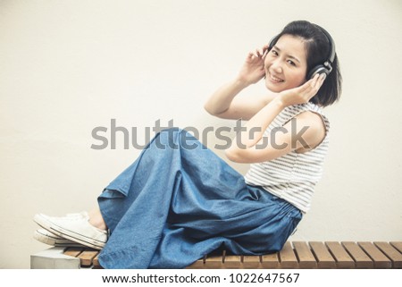 beatiful asian woman in casual costume enjoy music from headphone with happiness moment