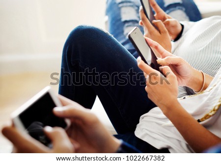 Friends using smartphone together at home Royalty-Free Stock Photo #1022667382