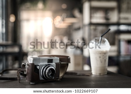 Closeup vintage film camera with coffee in cafe