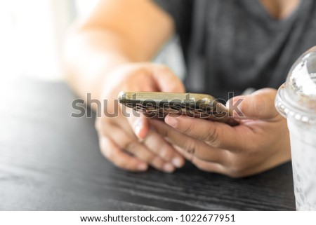 Hands using smartphone in cafe, lifestyle concept.
