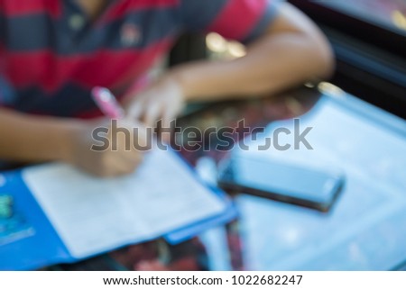 Blur image of man fill out application with camera and smart phone on the table background