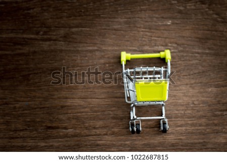 Shopping cart on wood background, shopping online, space for text.